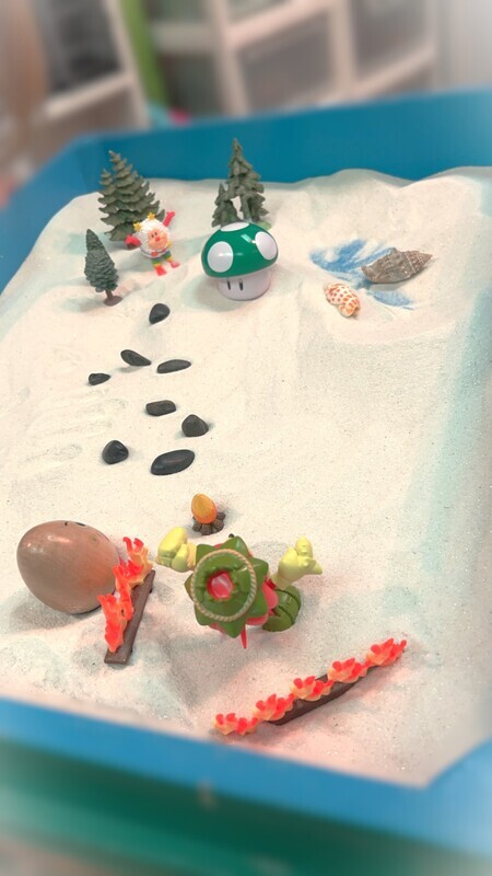 Vertical image of a sandtray full of items for sandtray emdr therapy